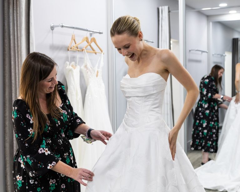 Bride in a strapless gown being fitted by a VBB consultant