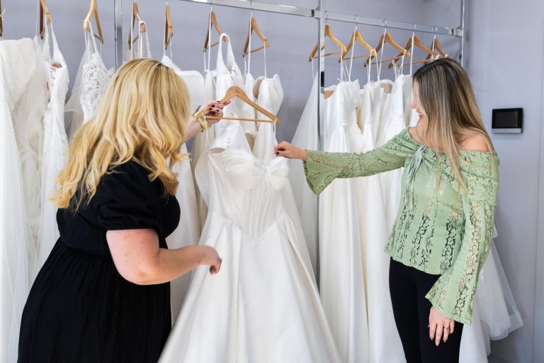 Consultant and bride looking at a wedding dress on the rail