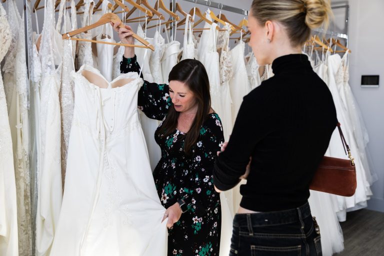 VBB consultant holding up a wedding dress for a bride